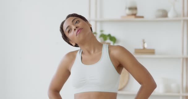 若いアフリカ系アメリカ人女性の家庭での訓練、首のための暖かい運動、スローモーションを行う — ストック動画