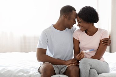 Genç siyah çift ebeveyn olacak ve pozitif gebelik testi yapacaklar.