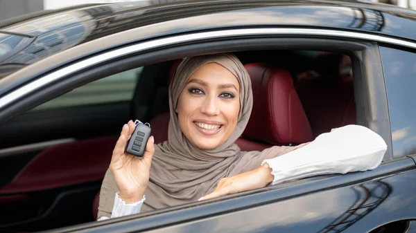 운전자 좌석에 앉아 자동차 키를 보여 주는 이슬람 여성 — 스톡 사진