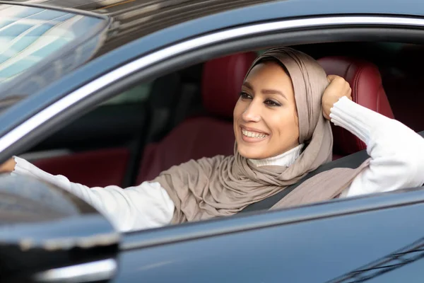 Fröhliche Muslimin am Steuer ihres neuen Autos — Stockfoto