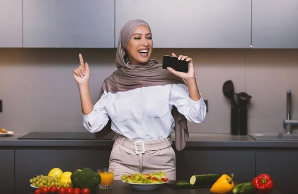 Örömteli arab nő szórakozás a konyhában, éneklés gazdaság Okostelefon — Stock Fotó