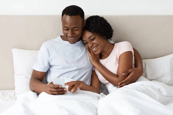 Loving Afrikaans Amerikaans paar samen kijken naar foto 's op de smartphone — Stockfoto