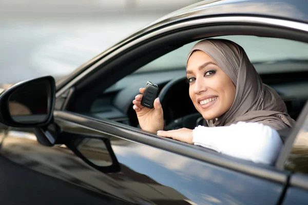 Jonge moslim dame met autosleutels, zittend op de bestuurdersstoel — Stockfoto