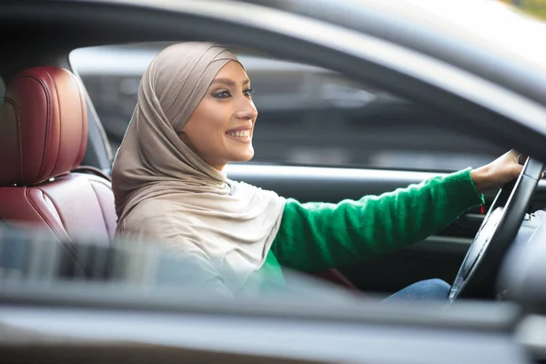 Glimlachende moslim vrouw rijden haar nieuwe auto in de stad — Stockfoto