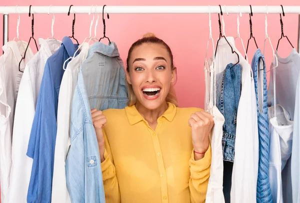 Radosna kobieta krzyczy z radości wybierając ubrania — Zdjęcie stockowe