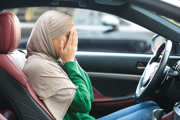 Droevige moslim vrouw die haar auto bestuurt, huilt, gezicht bedekt — Stockfoto