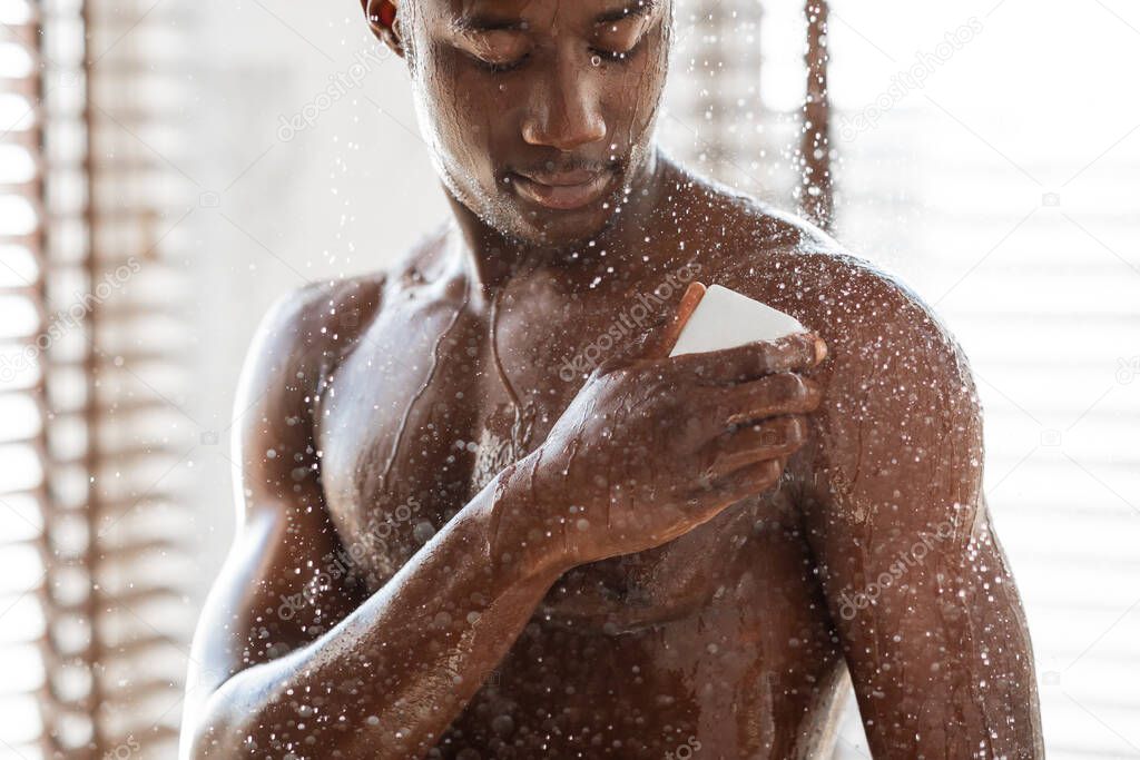 African Man Taking Shower Washing Torso With Soap In Bathroom