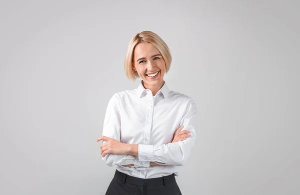 Portrait de femme d'affaires heureuse et confiante debout avec les bras croisés sur fond de studio gris clair, panorama — Photo