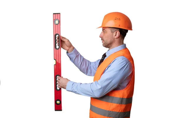 Construtor segurando o nível de construção trabalhando em pé sobre fundo branco, vista lateral — Fotografia de Stock