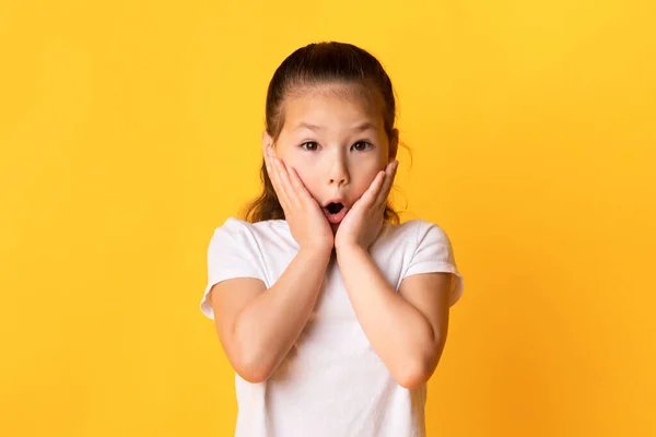 Asiático criança com boca aberta tocando bochechas em excitação — Fotografia de Stock