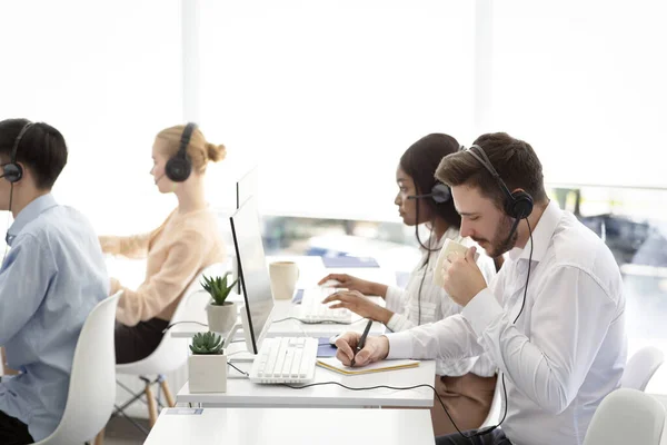 Equipe multinacional de operadores de suporte técnico no trabalho no escritório moderno do call center — Fotografia de Stock