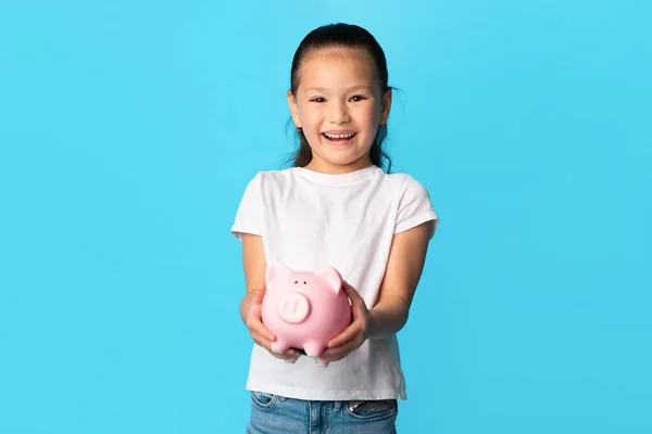 Menina segurando porquinho banco, estúdio tiro, espaço de cópia — Fotografia de Stock