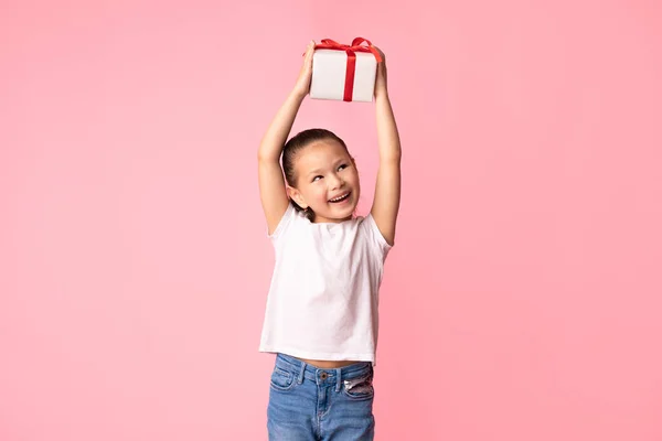 Verspielt asiatisch mädchen holding gift box bei studio — Stockfoto