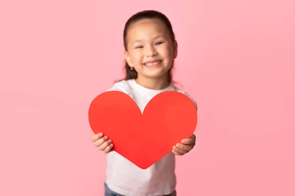 Asiática niña sosteniendo papel corazón en las manos — Foto de Stock