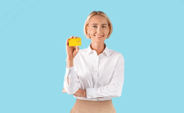 Porträt einer Geschäftsfrau mit goldener Kreditkarte vor blauem Studiohintergrund, Panorama — Stockfoto