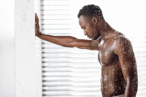 Desnudo negro chico tomando ducha lavado cuerpo en moderno cuarto de baño —  Fotos de Stock