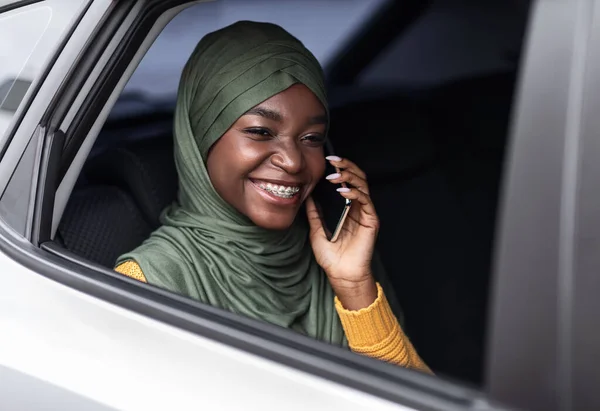 Comfortabel vervoer. zwart moslim vrouw met auto rijden en praten op mobiele telefoon — Stockfoto