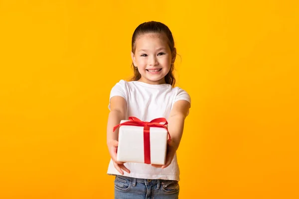 Glücklich asiatisch mädchen giving sie gift box bei orange studio — Stockfoto