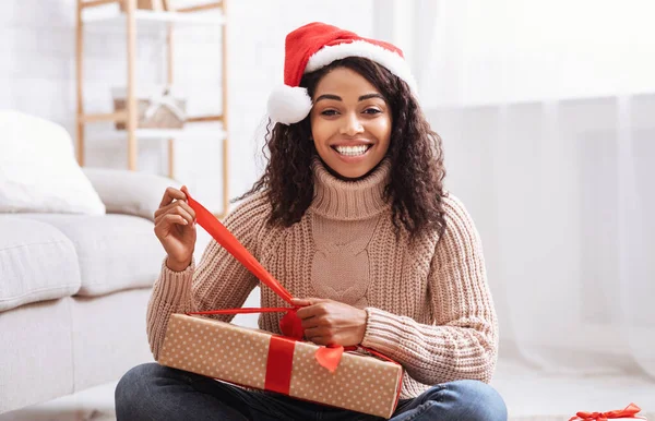 Czarna kobieta otwiera pudełko z prezentami w domu — Zdjęcie stockowe