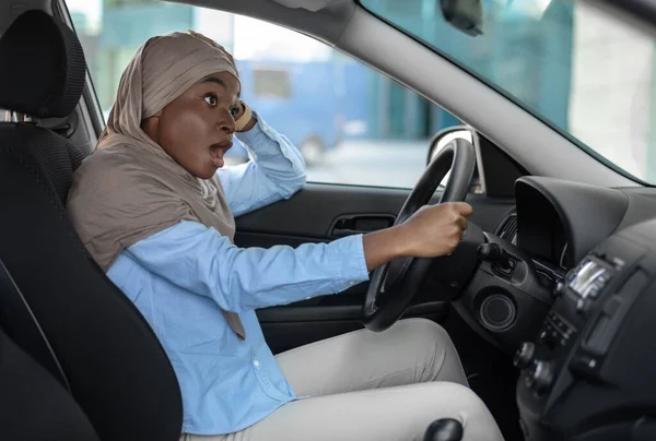 Shocked african muslim woman having car accident, her auto hit by another vehicle