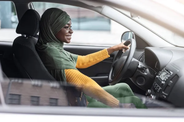 Zelfverzekerde zwarte moslim vrouw in hidjab genietend van autorijden in de stad — Stockfoto