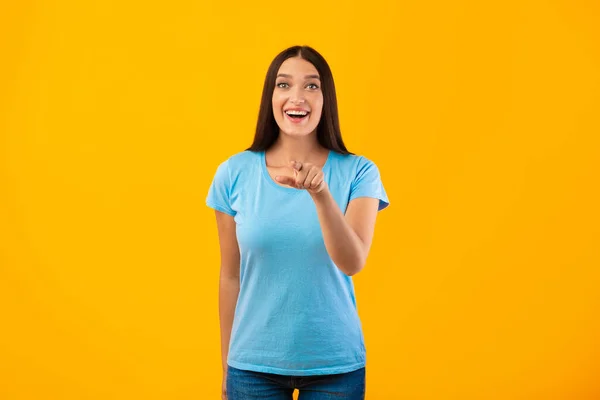 Mujer feliz señalando con el dedo a la cámara en el estudio — Foto de Stock