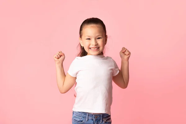 Feliz poco asiático chica sacudiendo puños, haciendo ganador gesto — Foto de Stock