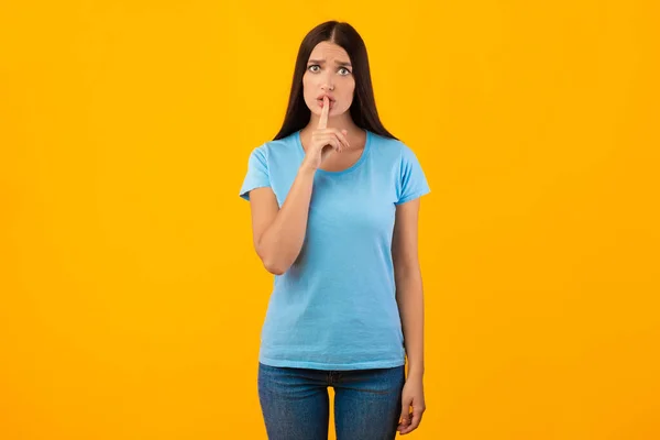 Vrouw die vinger op zijn lippen legt, zwijgzaam gebaar maakt — Stockfoto