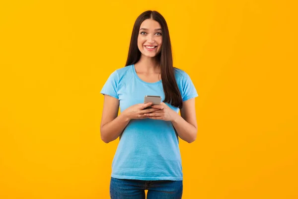 Happy vrouw met behulp van haar mobiele telefoon in de studio — Stockfoto