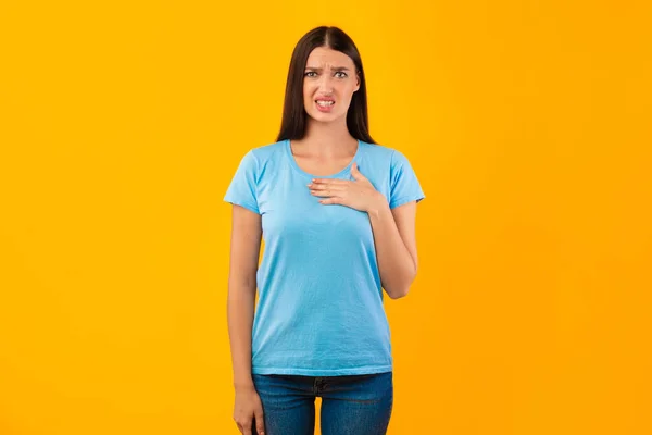 Retrato de mulher irritada segurando a mão em seu peito — Fotografia de Stock