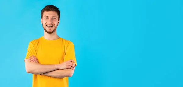 Lächelnder selbstbewusster Mann posiert auf blauem Hintergrund — Stockfoto
