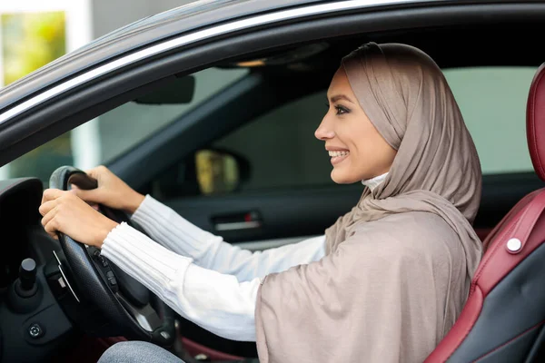 Vrolijke glimlachende moslim vrouw rijdt alleen haar nieuwe auto — Stockfoto