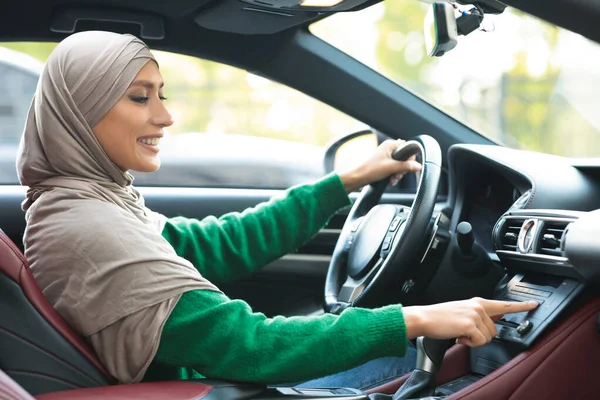 Vrolijke moslim vrouw rijden auto, met behulp van dashboard — Stockfoto