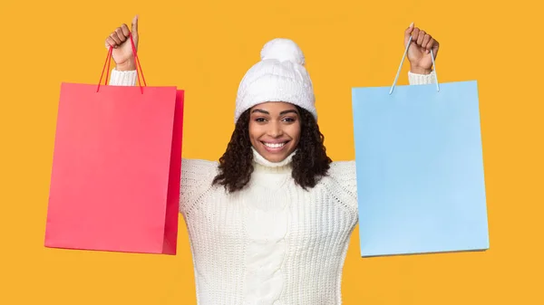 Mujer negra sosteniendo y mostrando dos bolsas de compras —  Fotos de Stock