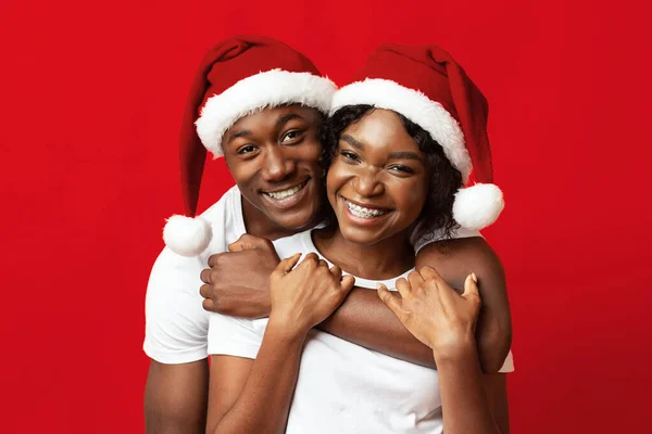 Jóvenes amantes negros en los sombreros de Santa divertirse en rojo — Foto de Stock