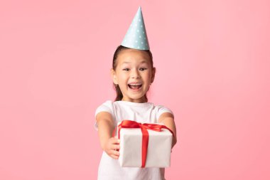 Mutlu Asyalı kız pembe stüdyoda sana hediye paketi veriyor.