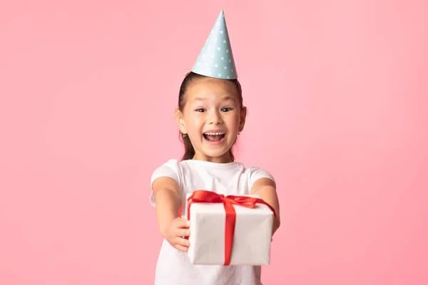Gelukkig aziatische meisje geven u gift doos in roze studio — Stockfoto