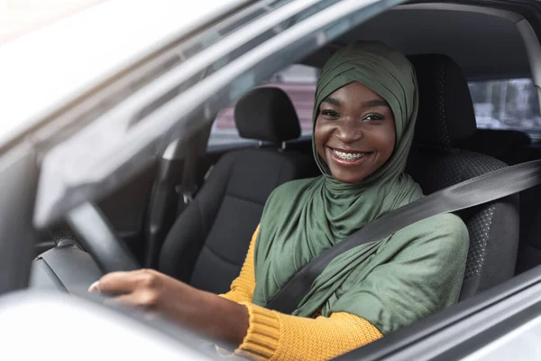 Portret van vrolijke Afrikaanse moslim vrouw in auto, genietend van road trip — Stockfoto