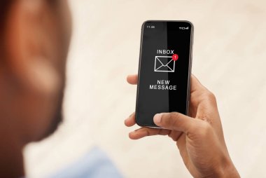 Akıllı telefonu kullanan Afrikalı adam içeride e-posta okuyor, kırpılmış