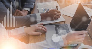 Bilgisayarlı ve belgeli iş arkadaşları ofiste çevrimiçi proje yaratıyor, sanal ekranda finansal verilerle kolaj yapıyor