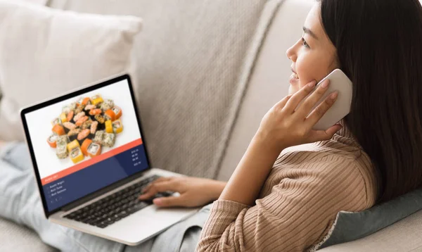 Modern gadgets for home delivery. Asian woman sits on sofa, ordering set of sushi
