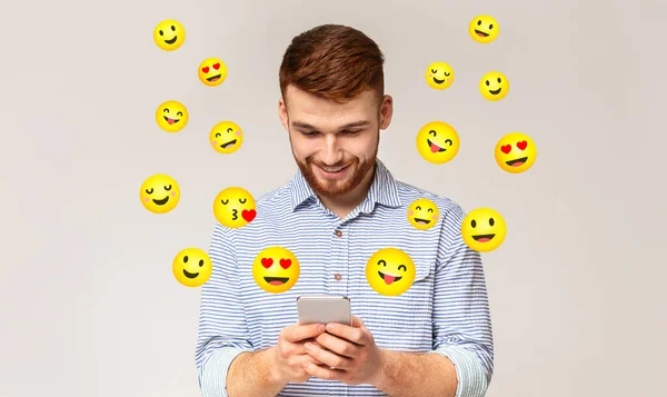 Ευτυχισμένος νεαρός άνδρας που στέλνει μηνύματα στο κινητό του — Φωτογραφία Αρχείου