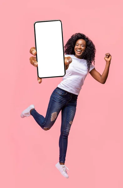 兴奋的黑人女士拿着智能手机跳起来 — 图库照片