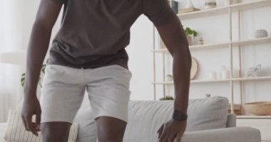 Kanepede oturan Afrikalı Amerikalı adam, Ukala 'nın yoğun eğitim sonuçlarını izliyordu.