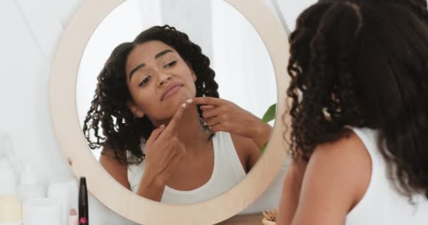 Problem skin concept. Sad african american lady looking at mirror and crushing pimple on her chin, back view — Stock Video