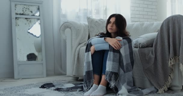 Sorgsen deprimerad ung dam sitter ensam på golvet insvept i rutig, känner smärta, lider av ensamhet hemma — Stockvideo