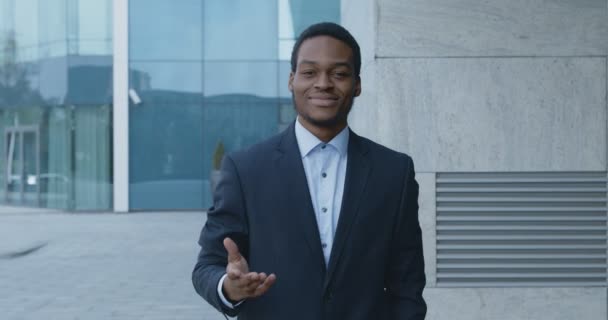 Barátságos afro-amerikai csapatvezető üdvözlő, meghívó új emberek közelében irodaház bejárata — Stock videók