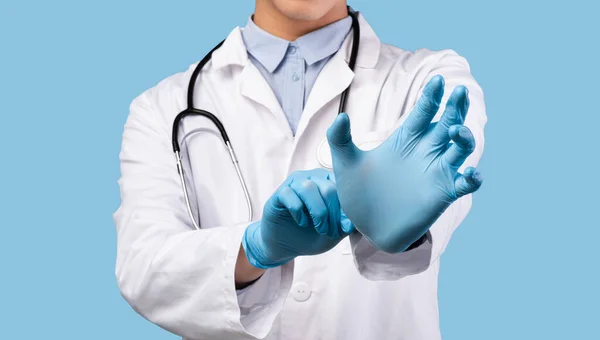 Чоловік лікар одягає і носить рукавички — стокове фото