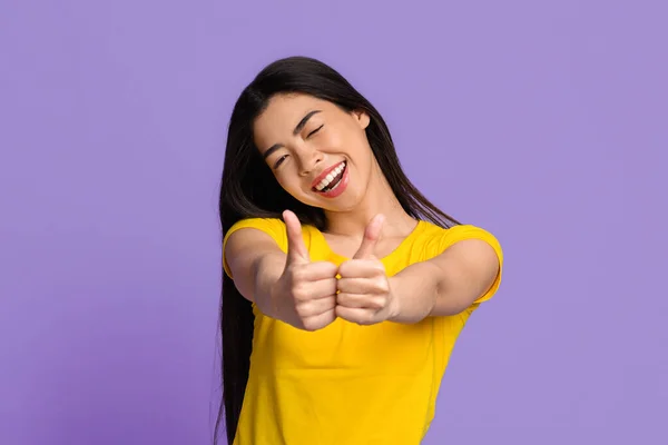 Líbí se mi to. Radostná mladá asijská žena ukazující palce nahoru na fotoaparátu — Stock fotografie