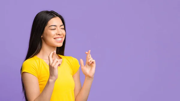 Desiderio caro. Giovane asiatico signora incrociando le dita, accattonaggio per fortuna — Foto Stock